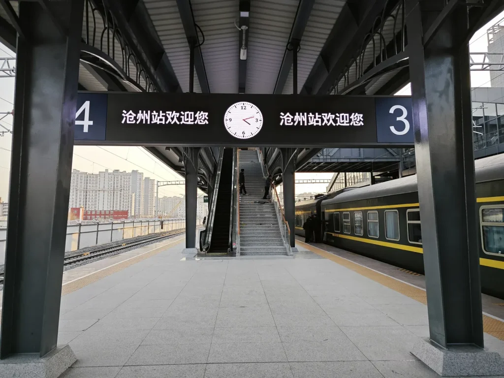Cangzhou Railway Station platform with train and station sign