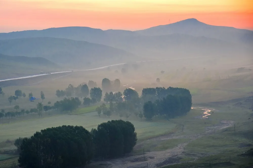 Morning mist and rolling grassland scenery in Fengning Bashang Grassland