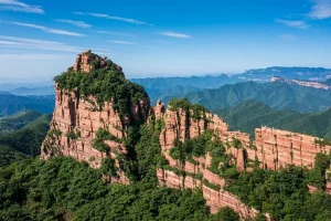 Red-rock cliffs and forested ridges at Zhangshiyan Scenic Area in Zanhuang, Hebei