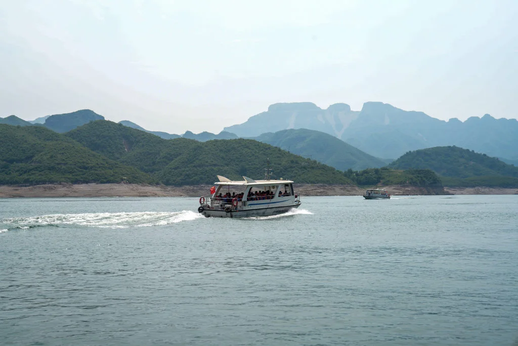 Cruise boat on Yishui Lake with the mountains of Yixian in the background