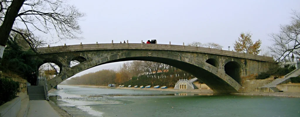 Wide riverside view of the stone arch of Zhaozhou Bridge in Zhao County