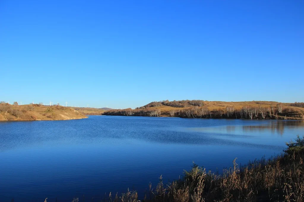 Real Saihanba National Forest Park landscape with water, open land, and a clear sky
