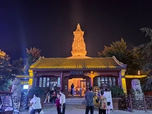 Illuminated Hua Pagoda rising behind the entrance gate of Guanghui Temple in Zhengding at night