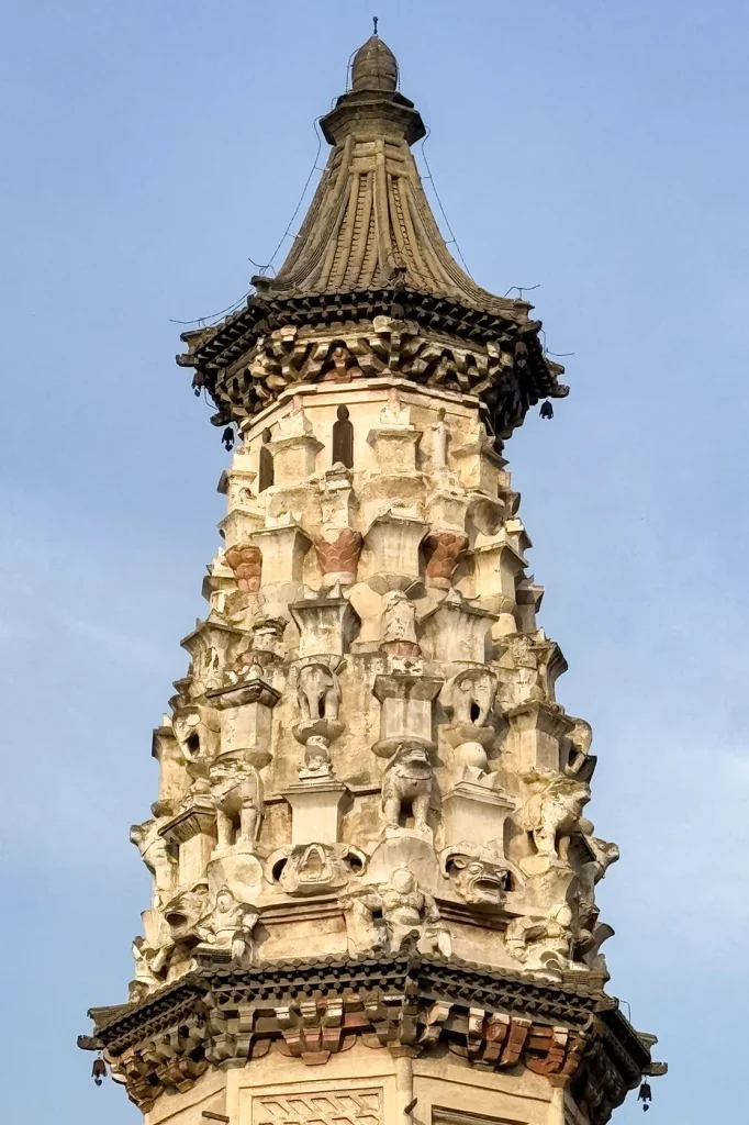 Close view of sculpted figures, animal forms and miniature towers beneath the roof of Zhengding Hua Pagoda