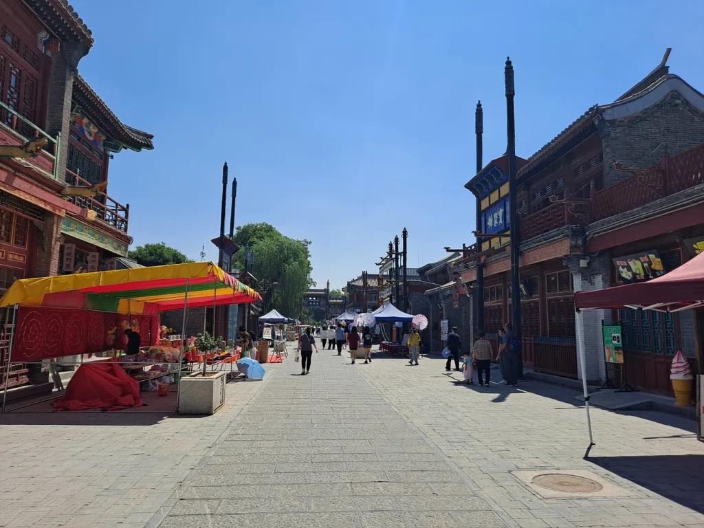 People walking between shopfronts on Ningrong Street in Zhengding